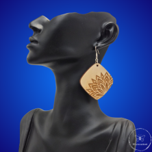 une paire de boucles d'oreilles en bois gravées au laser, avec un crochet en argent et un motif décoratif en métal. Très légères