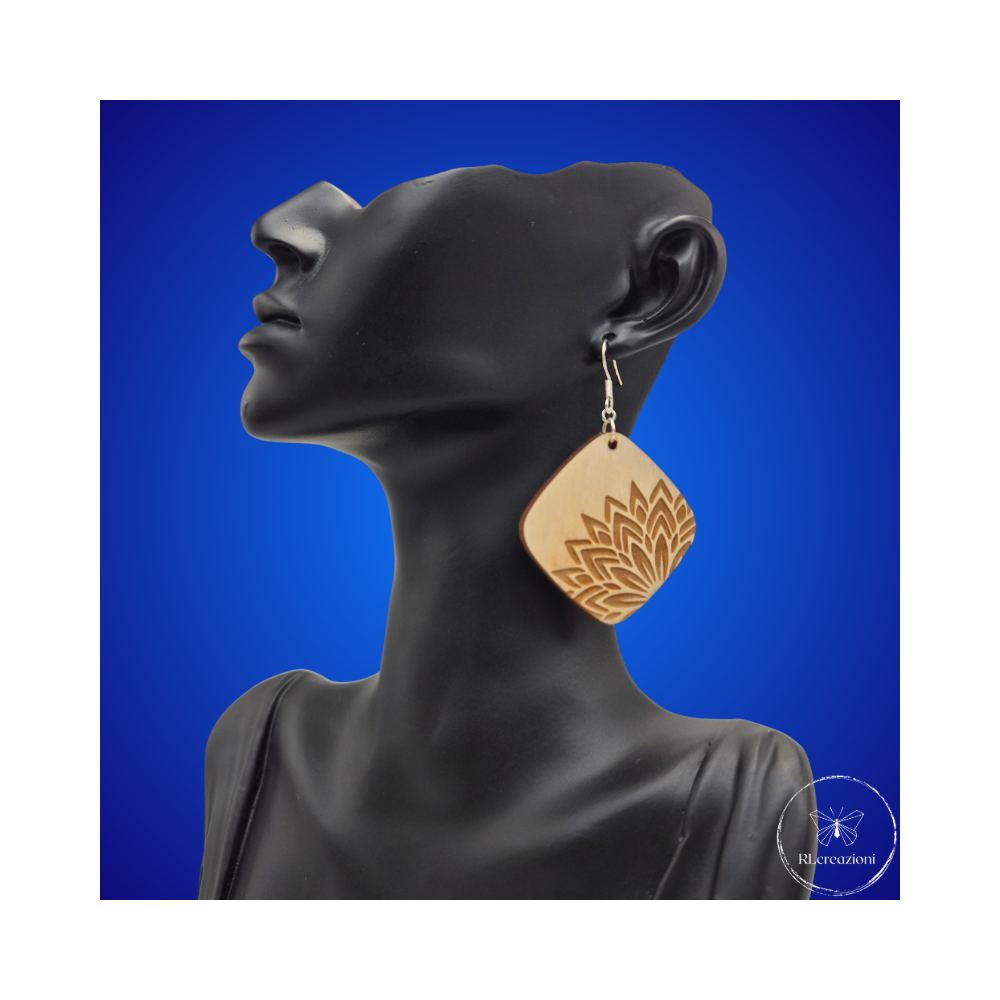 une paire de boucles d'oreilles en bois gravées au laser, avec un crochet en argent et un motif décoratif en métal. Très légères