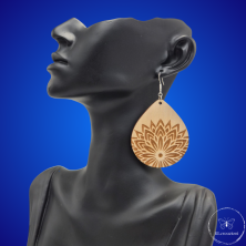 une paire de boucles d'oreilles en bois gravées au laser, avec un crochet en argent et un motif décoratif en métal. Très légères