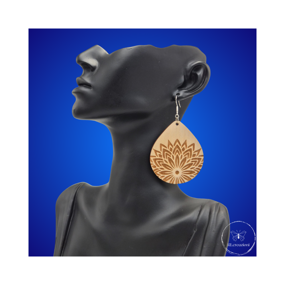 une paire de boucles d'oreilles en bois gravées au laser, avec un crochet en argent et un motif décoratif en métal. Très légères