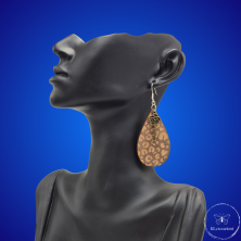 une paire de boucles d'oreilles en bois gravées au laser, avec un crochet en argent et un motif décoratif en métal. Très légères