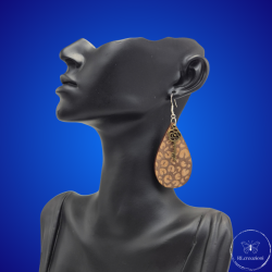 une paire de boucles d'oreilles en bois gravées au laser, avec un crochet en argent et un motif décoratif en métal. Très légères