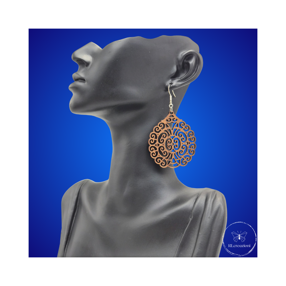 une paire de boucles d'oreilles en bois gravées au laser, avec un crochet en argent et un motif décoratif en métal. Très légères