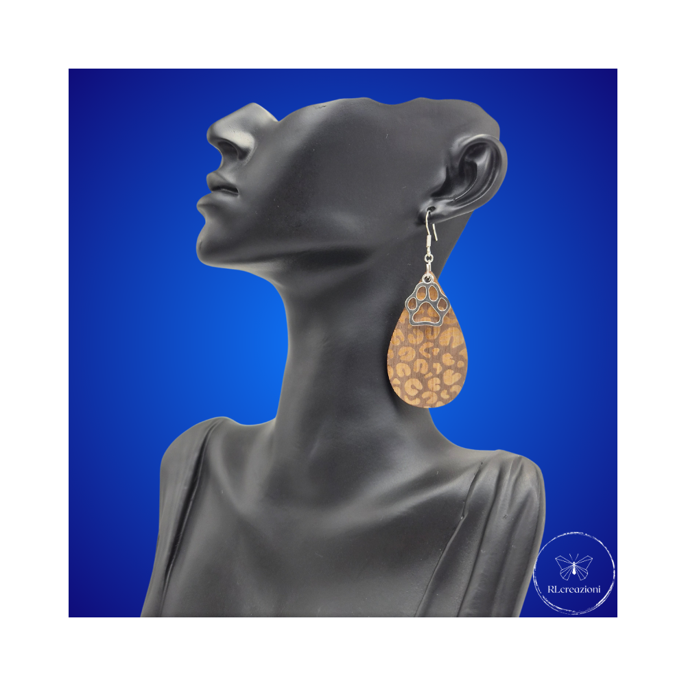 une paire de boucles d'oreilles en bois gravées au laser, avec un crochet en argent et un motif décoratif en métal. Très légères