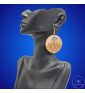 une paire de boucles d'oreilles en bois gravées au laser, avec un crochet en argent et un motif décoratif en métal. Très légères