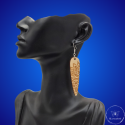 une paire de boucles d'oreilles en bois gravées au laser, avec un crochet en argent et un motif décoratif en métal. Très légères